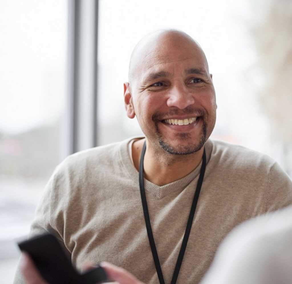Kollega på arbetsplatsen med telefon i handen