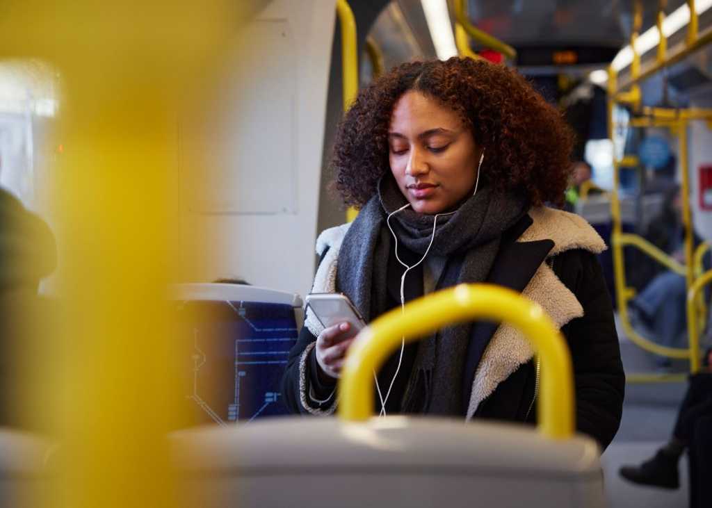 Marta läser i mobilen på väg till arbetet